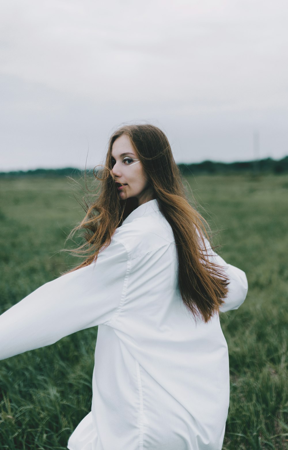 a woman standing in a field of tall grass