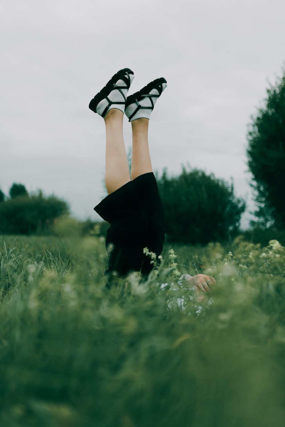 a woman laying in the grass with her legs up