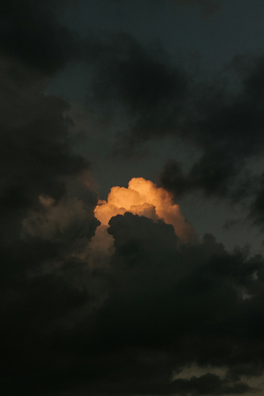 a large cloud in the sky with a yellow light