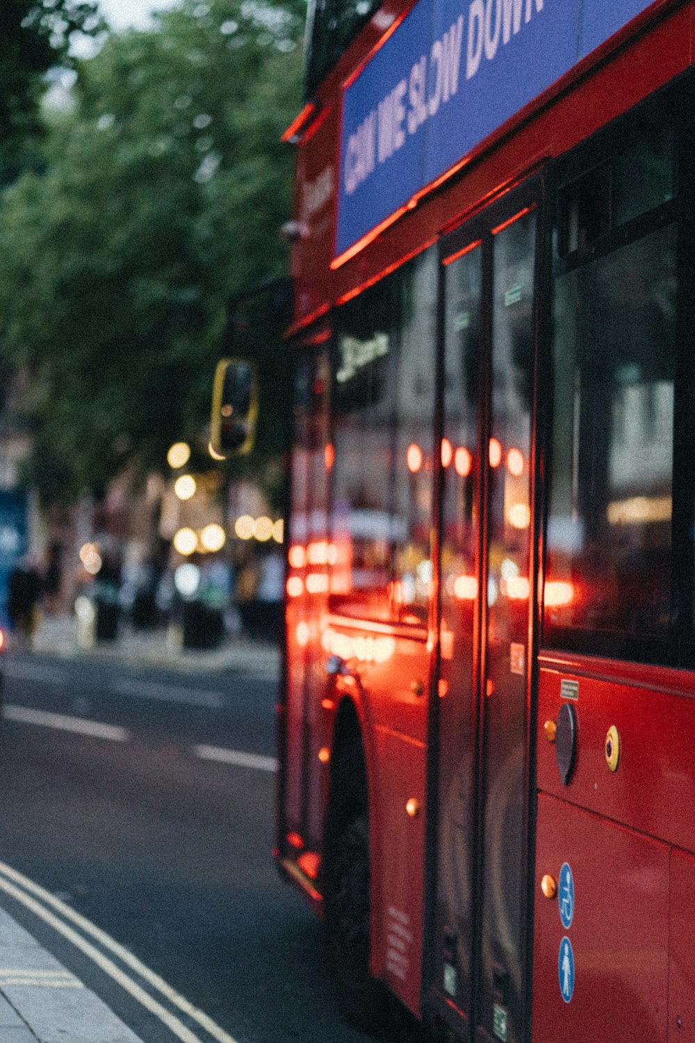 a red double decker bus driving down a street