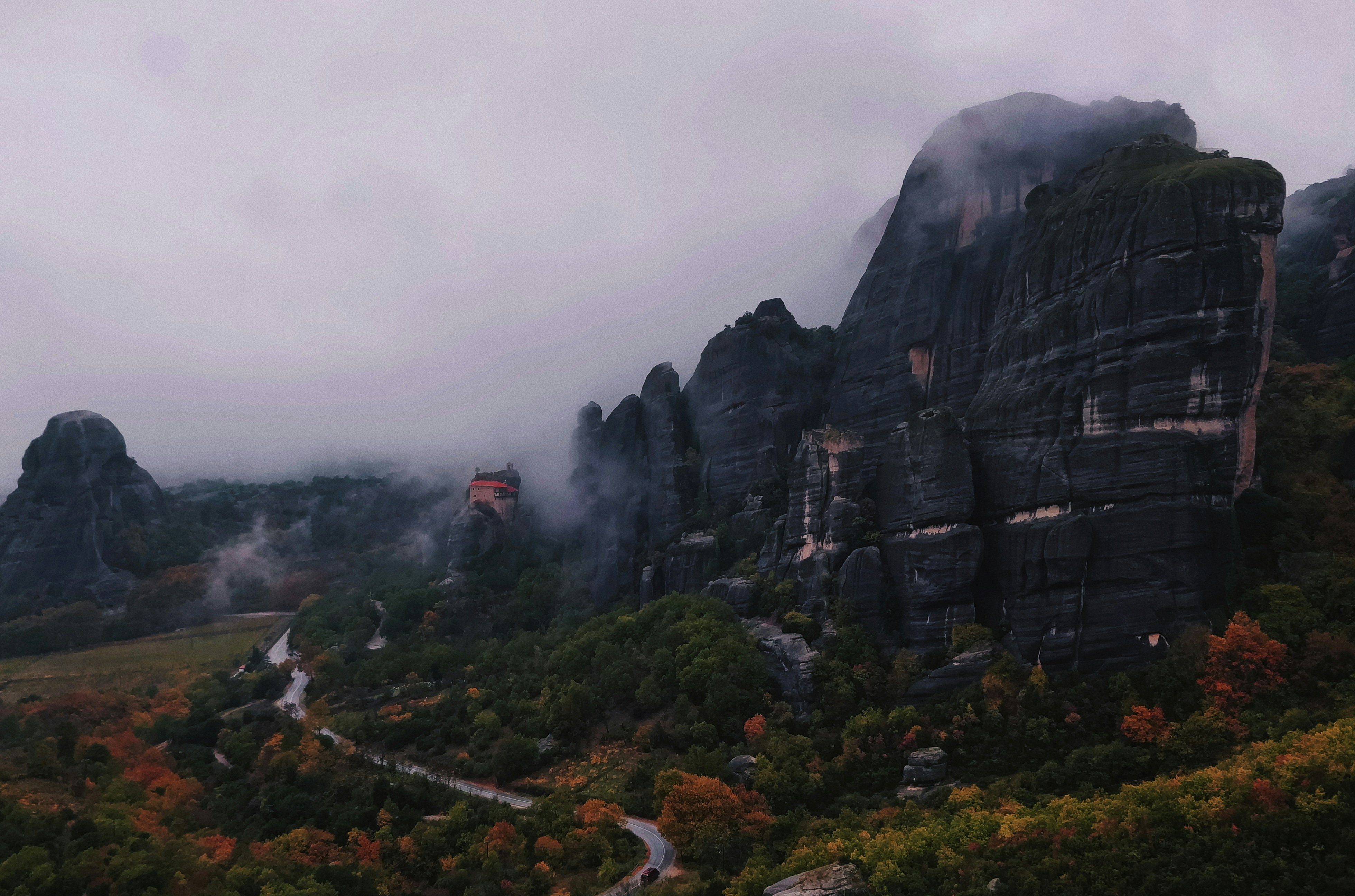 a scenic view of a mountain with a road winding through it