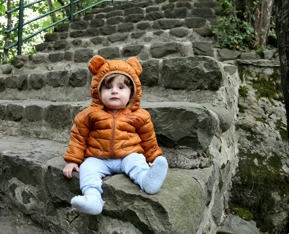 un petit enfant assis sur quelques marches