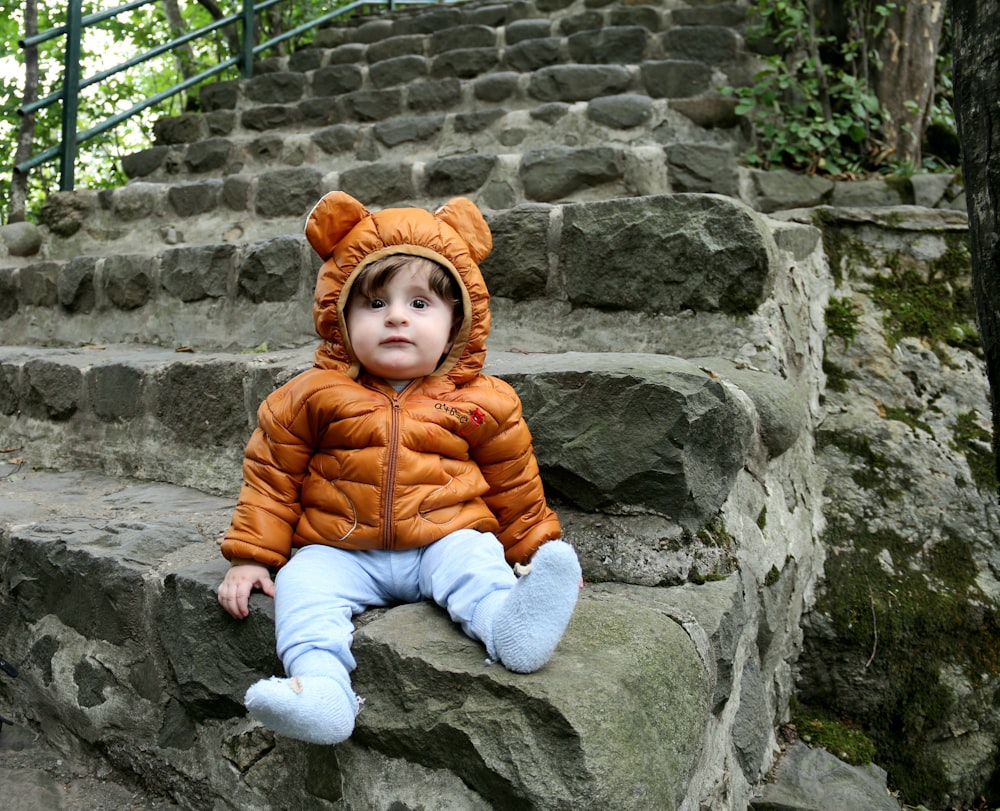 a small child sitting on some steps