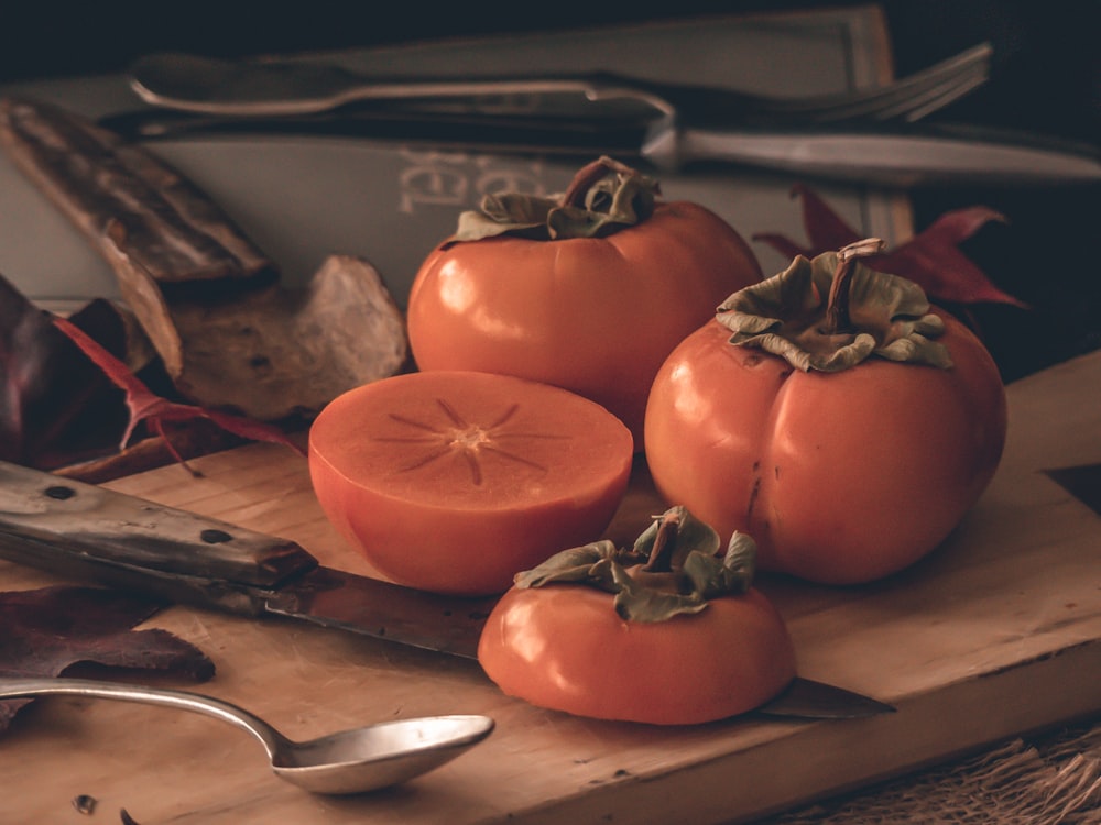 a group of tomatoes sitting on top of a cutting board