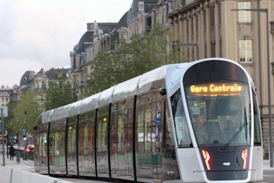 Modern tram-train running through Kinshasa cityscape near the airport.