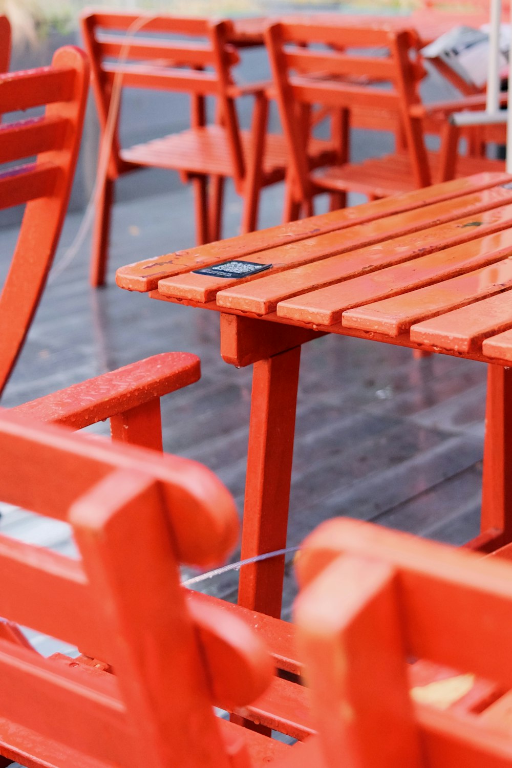 a row of red wooden benches sitting next to each other