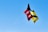A vibrant handmade kite with unique patterns flying in the sky.
