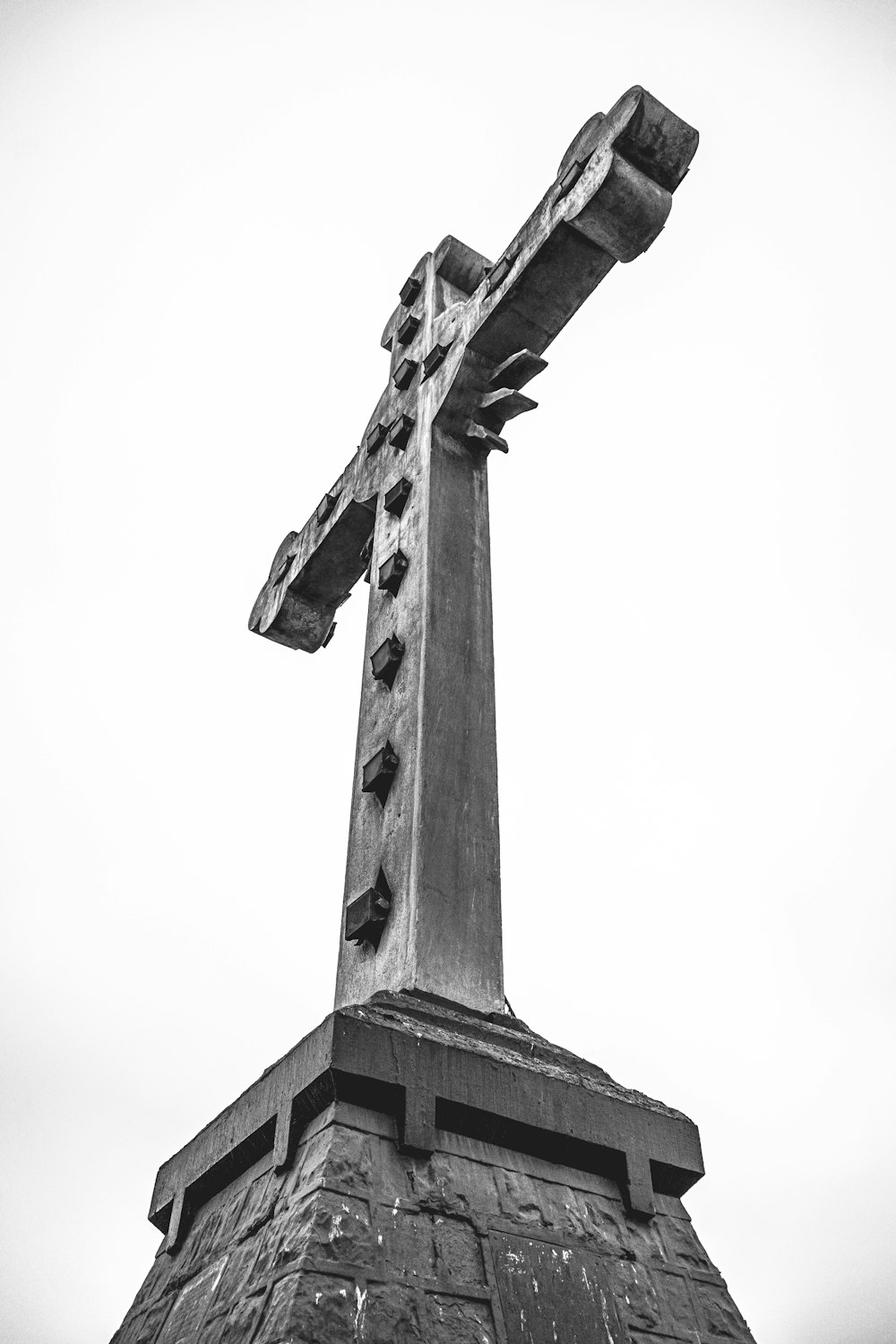 a black and white photo of a cross on top of a building