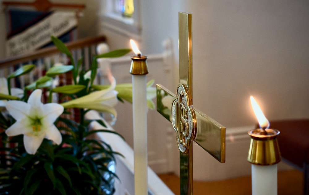two candles are lit in a church with flowers in the foreground