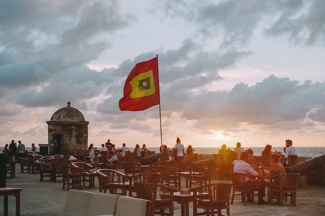 a group of people sitting at a table next to the ocean,
