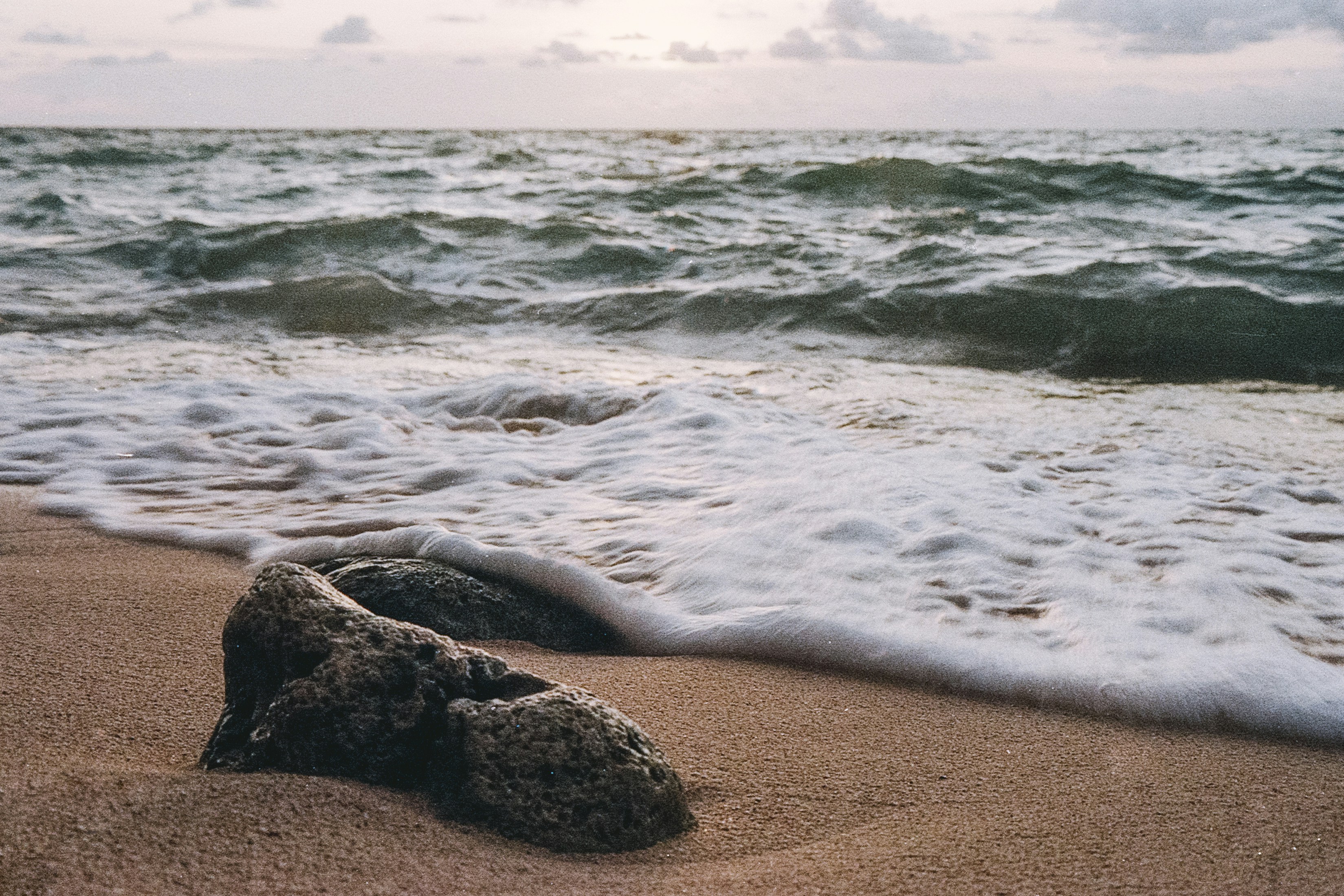 Una roca tendida en la playa junto al océano