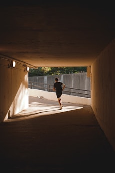 a man running in a tunnel under a bridge