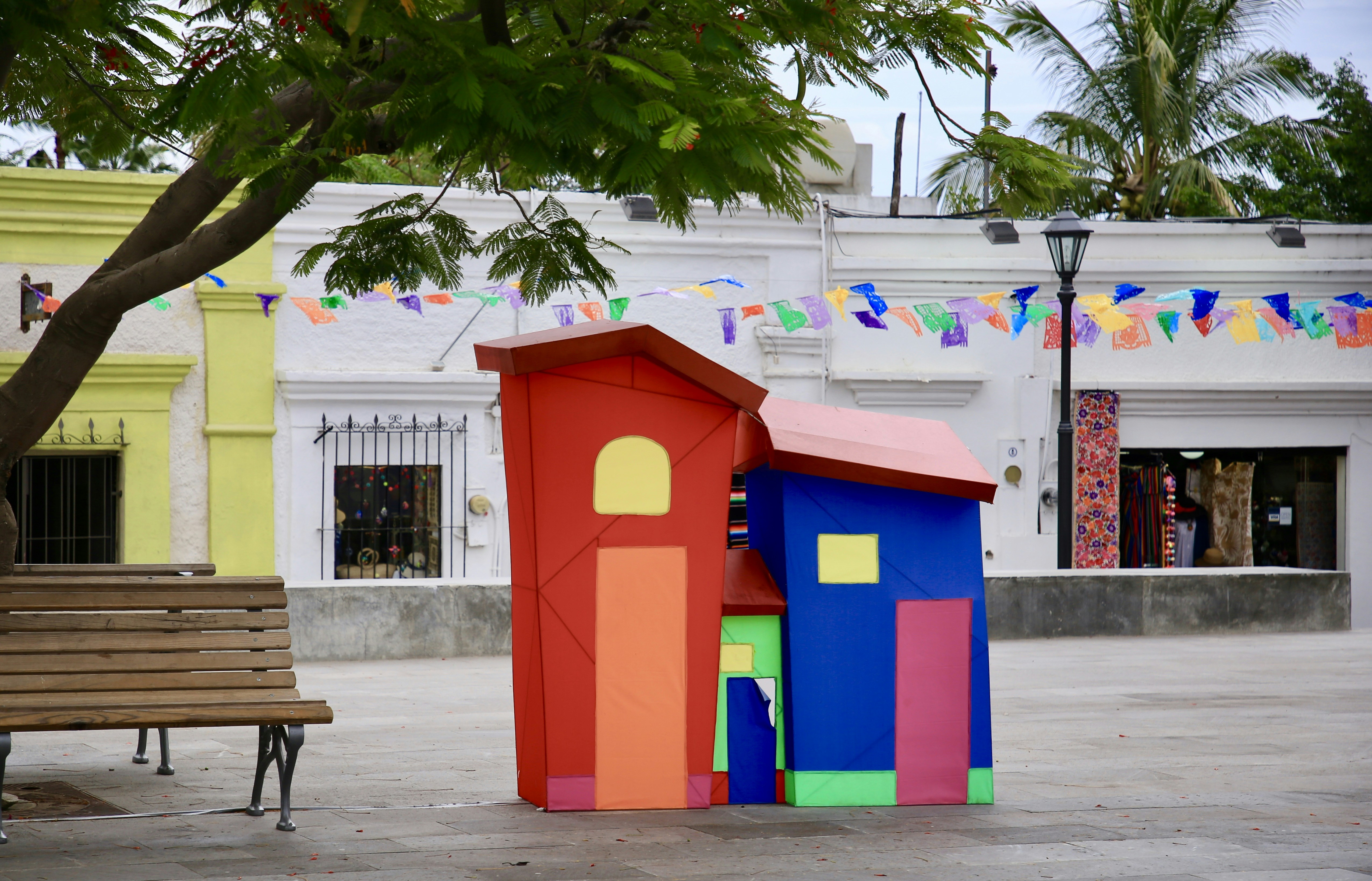 a bench and a colorful structure in the middle of a street