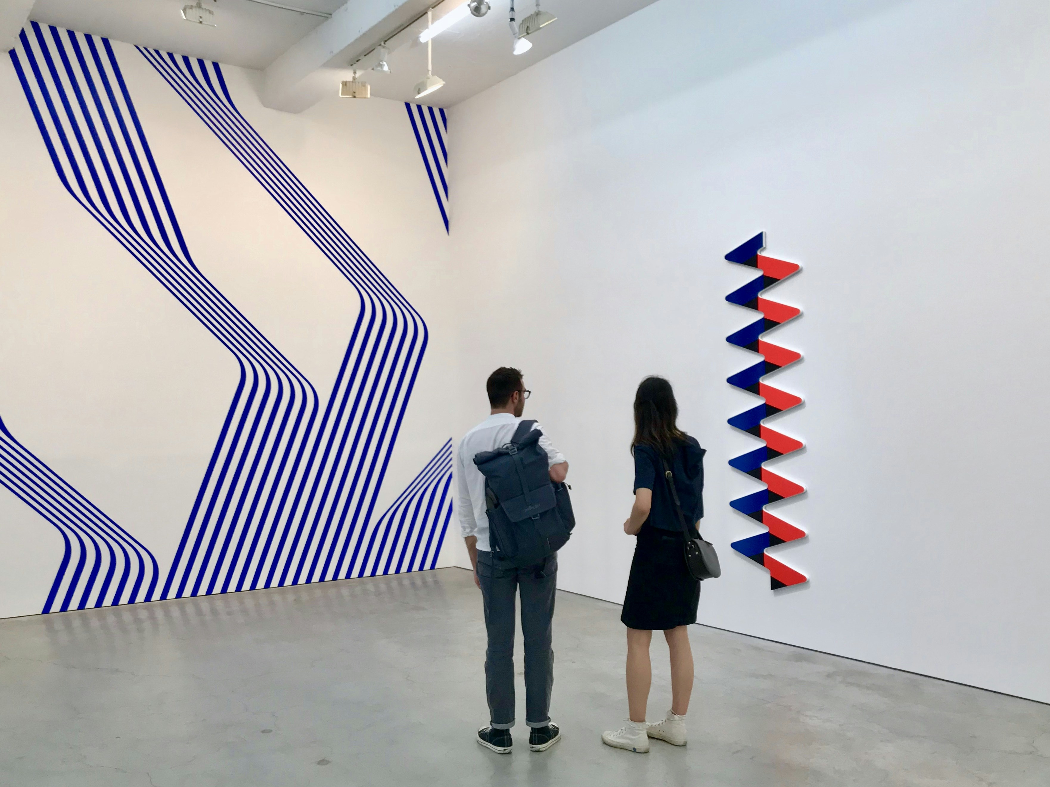 a couple of people standing in front of a wall