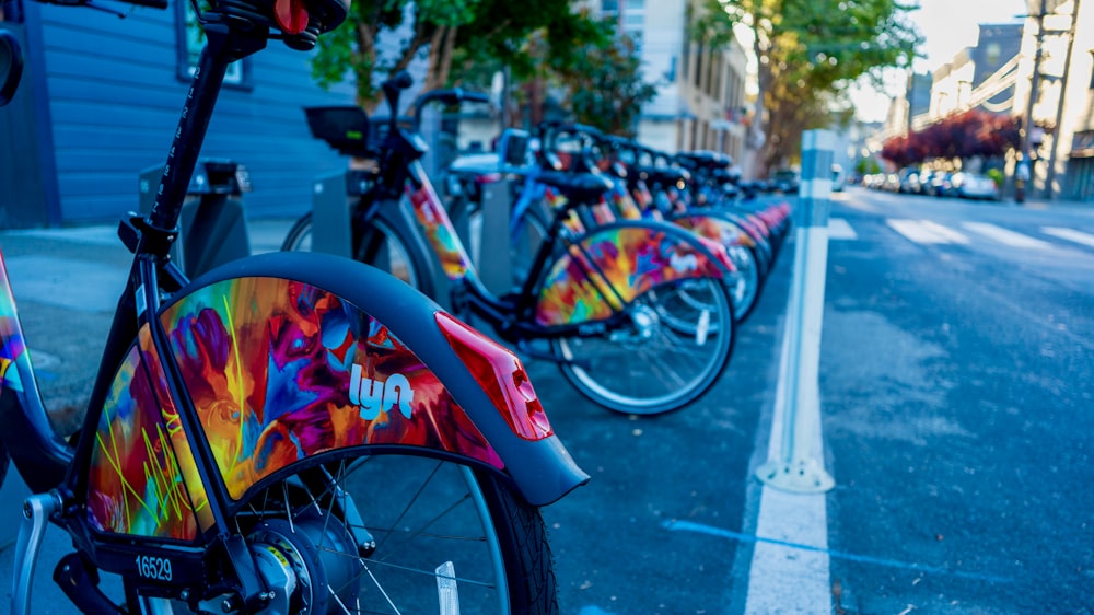 Una hilera de coloridas bicicletas estacionadas una al lado de la otra