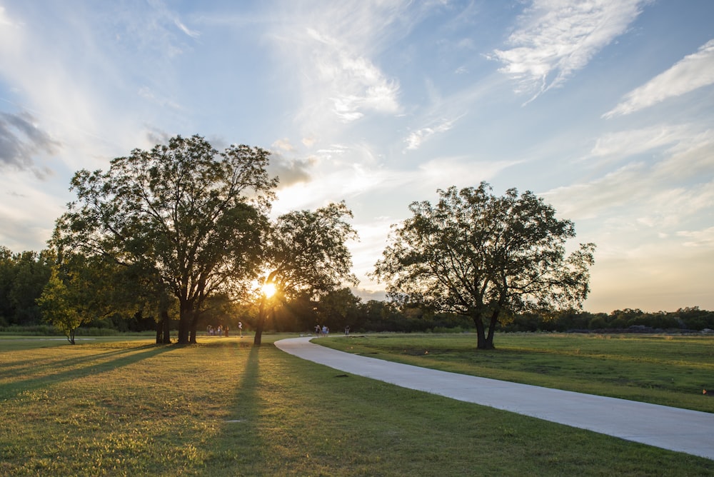 the sun is setting in the distance behind some trees