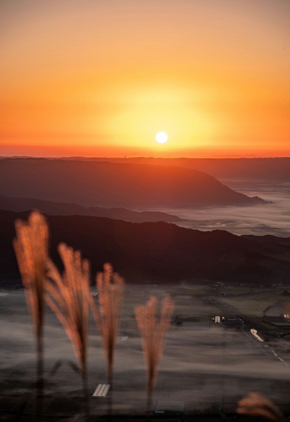 the sun is setting over a mountain range