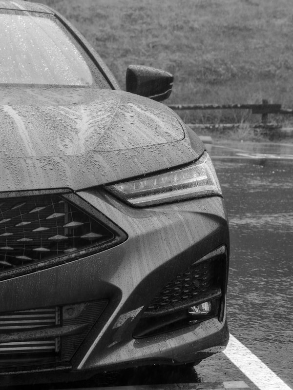 a black and white photo of a car in the rainby Ronan Furuta