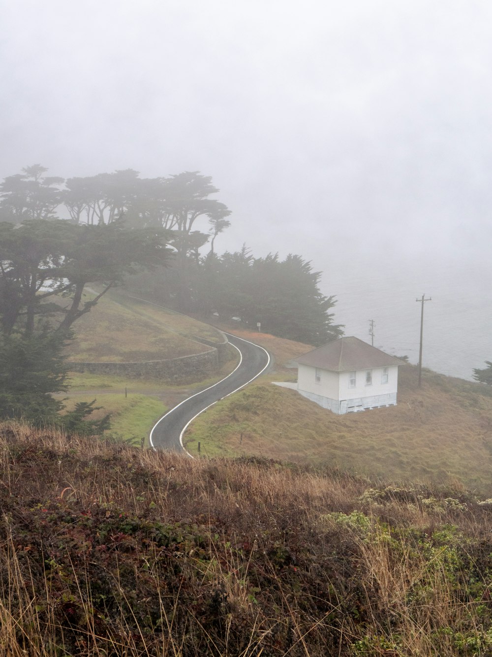 a house on a hill with a winding road in the foreground