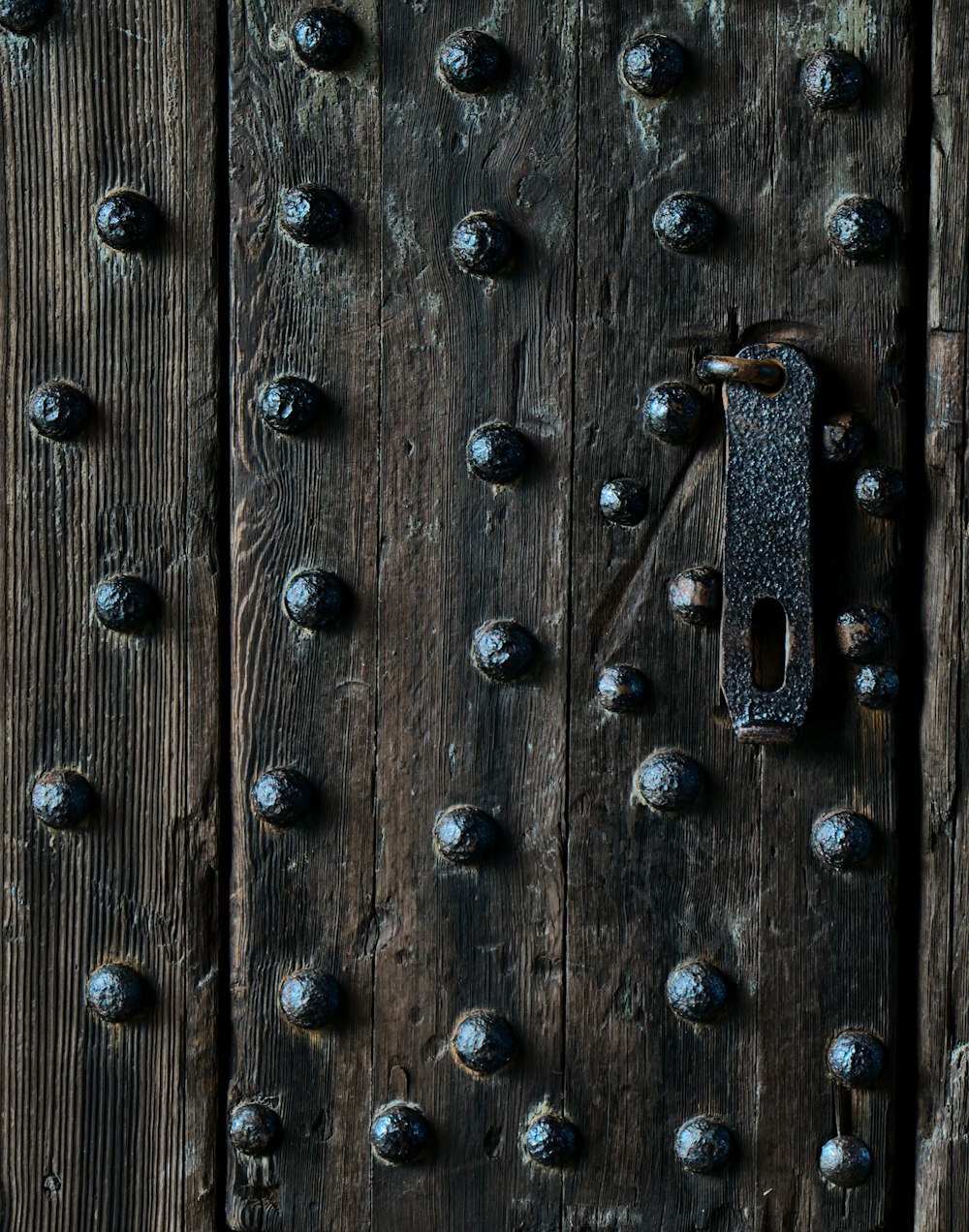 una puerta de madera con remaches metálicos