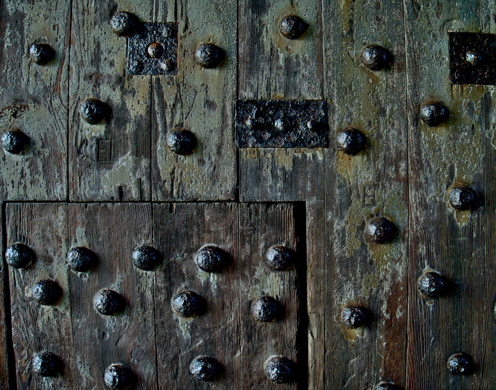 a close up of a wooden door with rivets