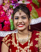A smiling woman in traditional attire looking hopeful and serene.