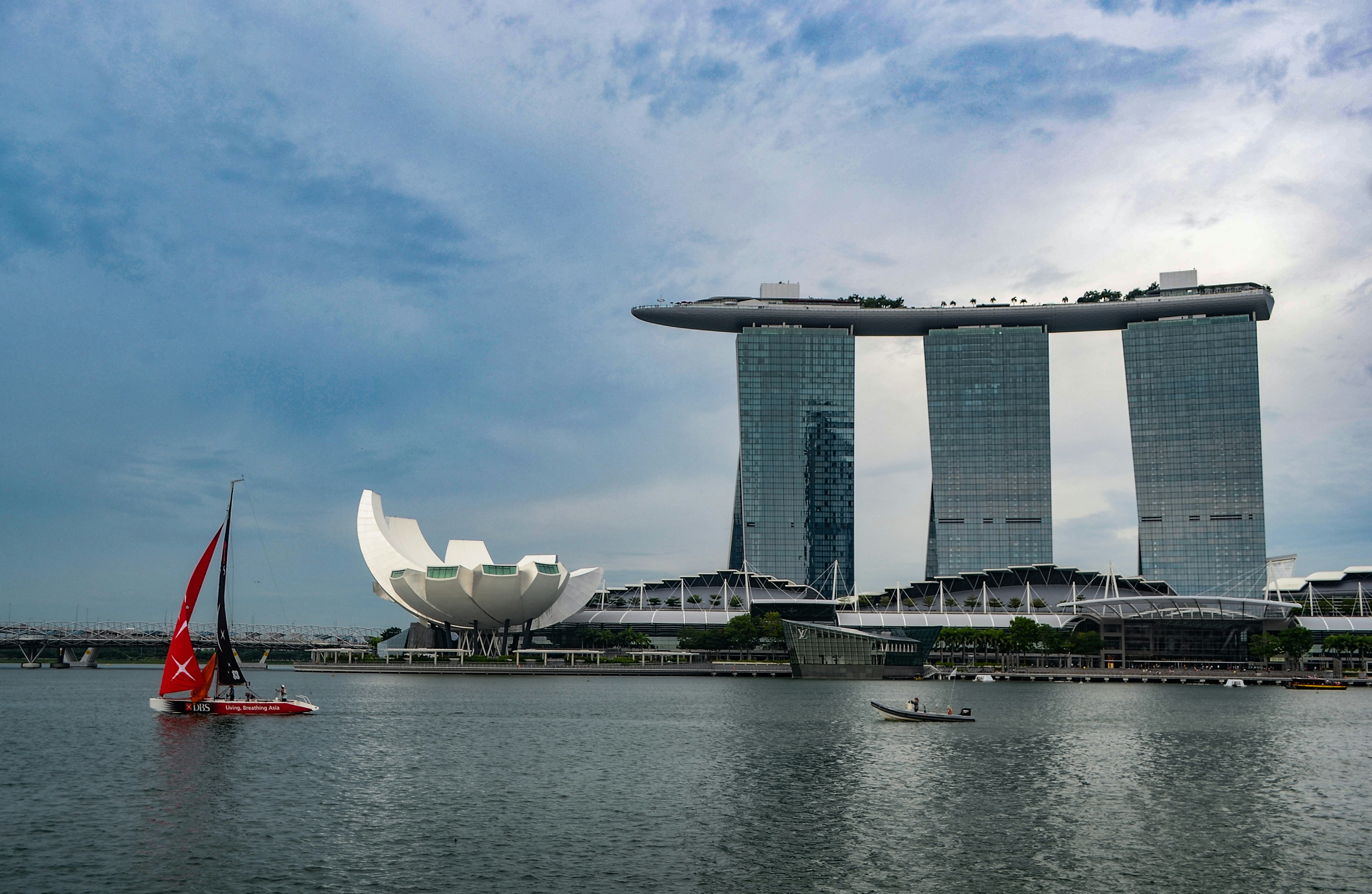 a sailboat on a body of water in front of some tall buildings