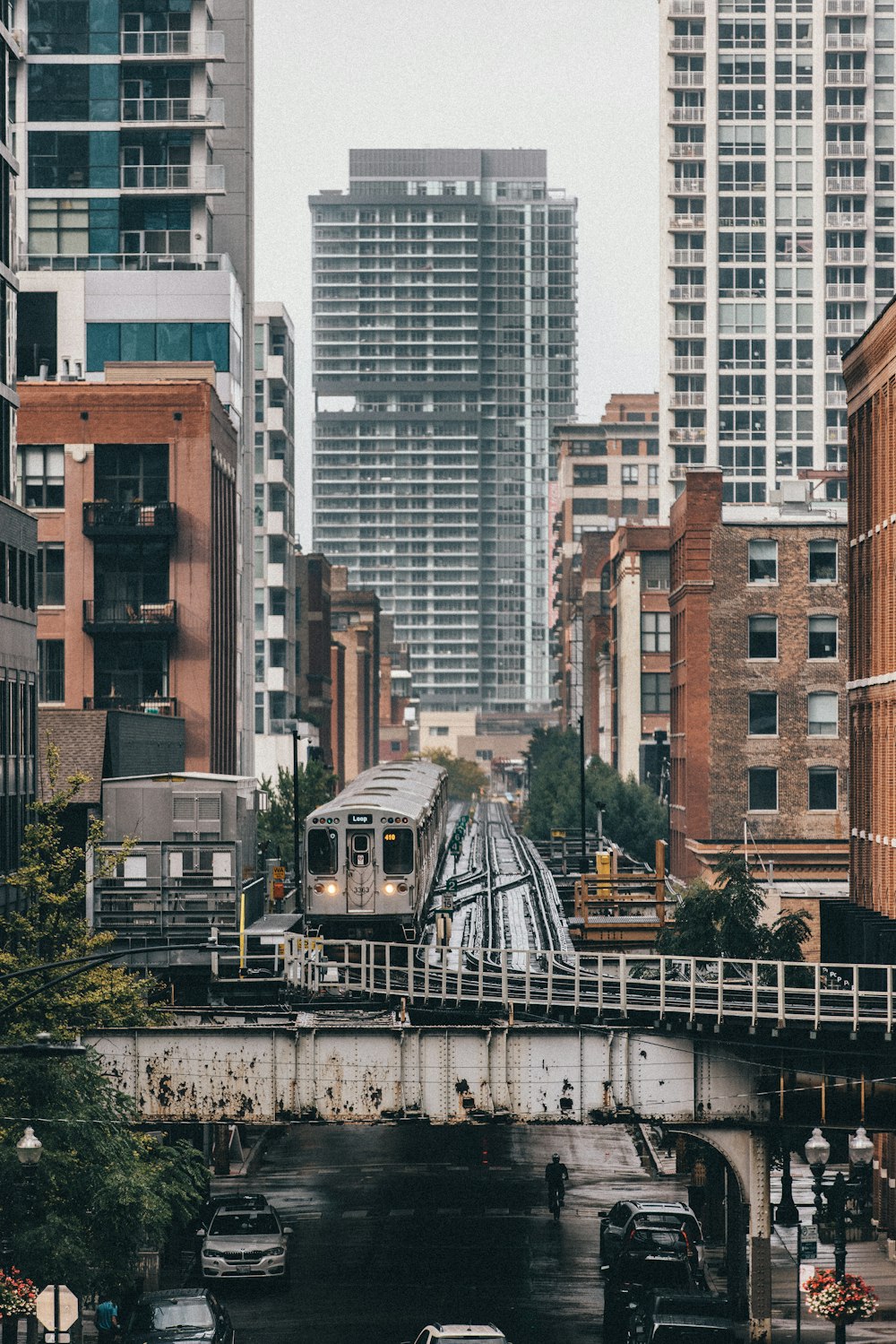 a train traveling over a bridge next to tall buildings