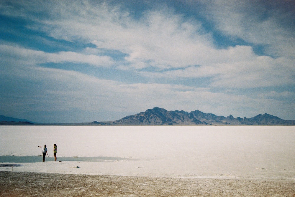 a couple of people standing in the middle of a desert