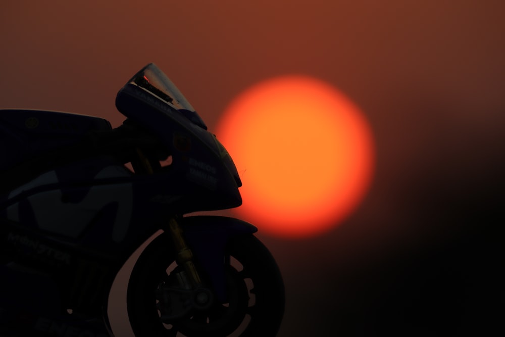 a close up of a motorcycle with the sun in the background