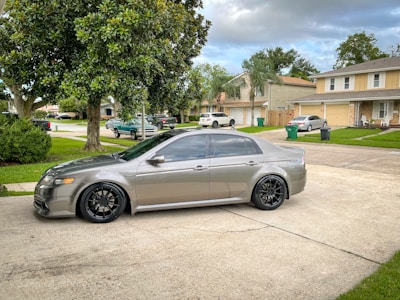 Sleek silver sedan parked on a suburban street with sunlight reflecting off its polished surface