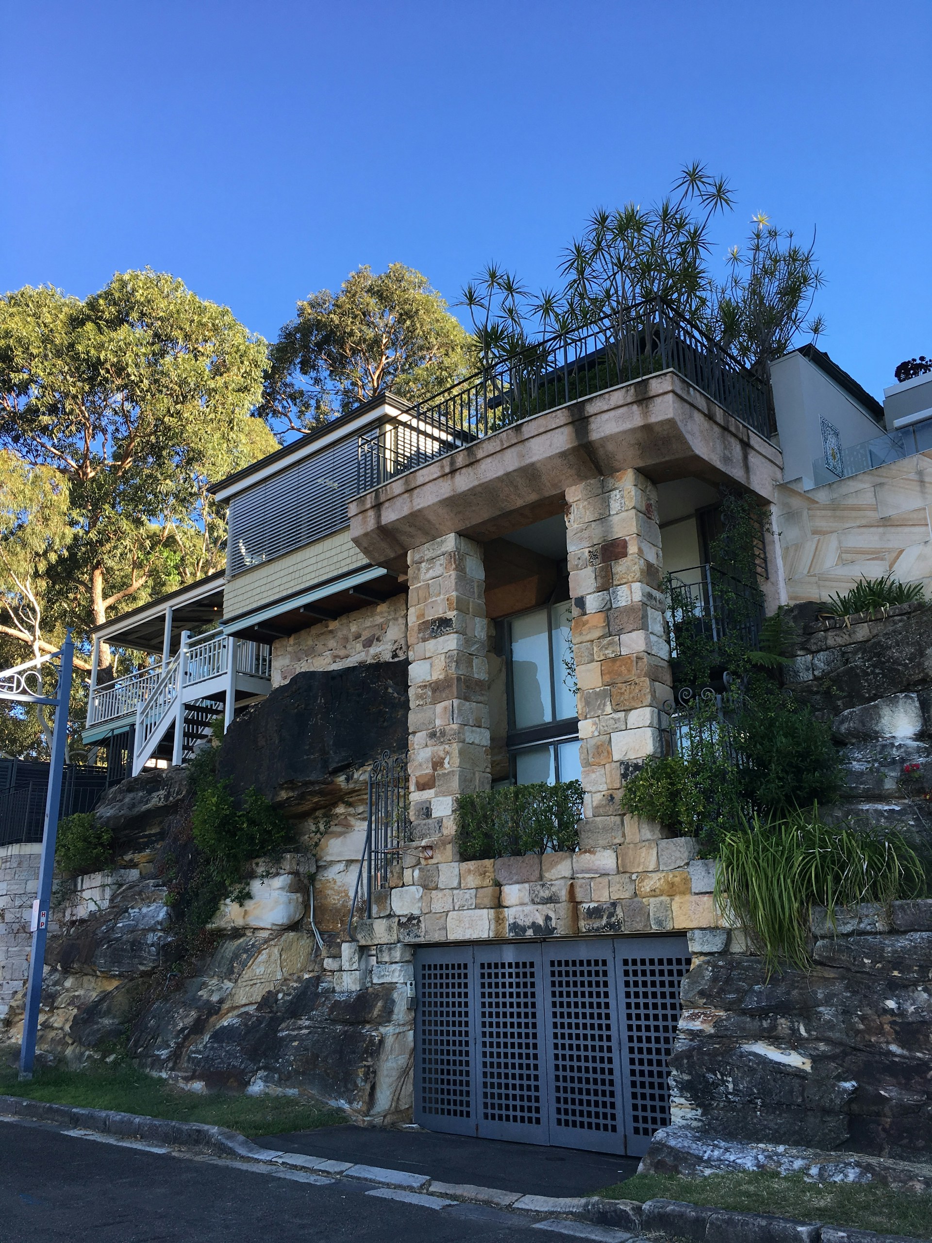 A stunning Texas custom home exterior showcasing elegant stonework and expansive windows under a clear blue sky.