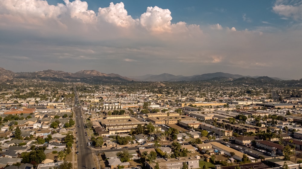 an aerial view of a city with mountains in the background