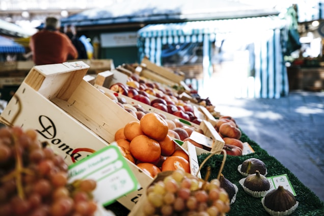 A vibrant display of freshly harvested fruits and vegetables arranged in wooden crates at a bustling market.