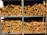 Several stacks of neatly chopped firewood are arranged on metal shelves. The wood pieces have a natural, rustic appearance with varying shades of brown and some visible bark. The shelves are organized in a neat and orderly fashion.