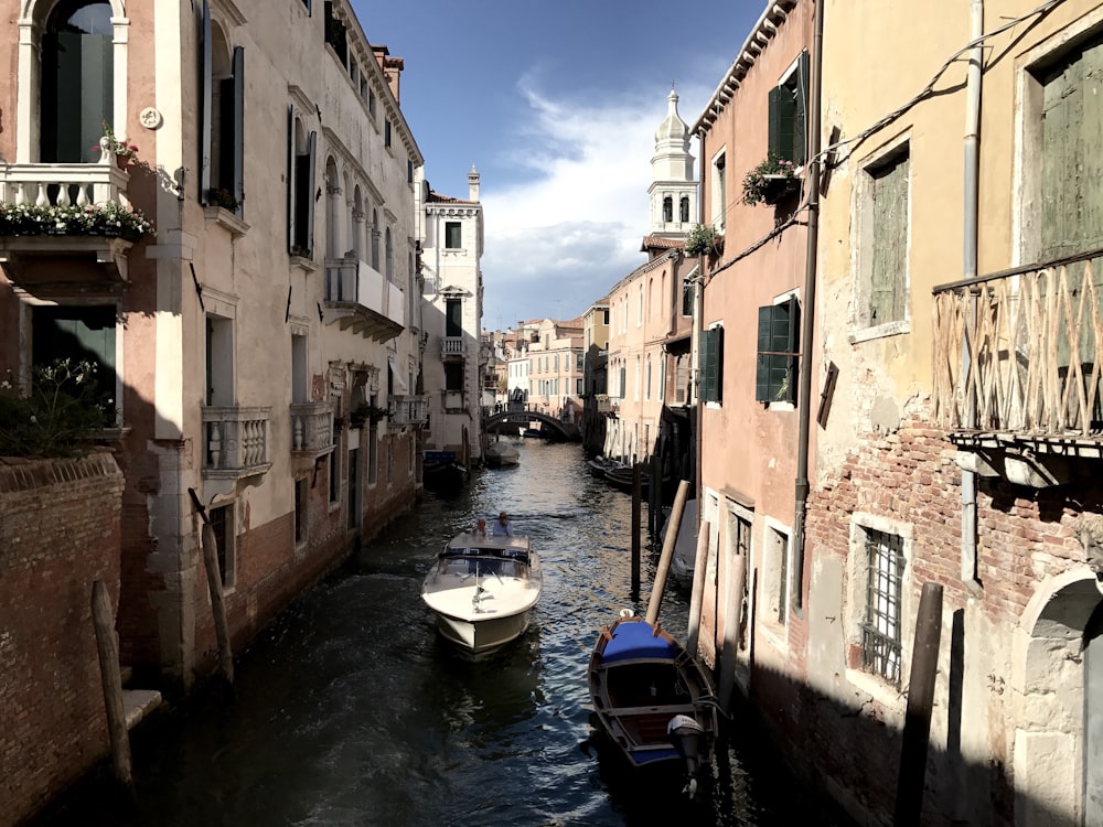 a small boat in a narrow canal between two buildings