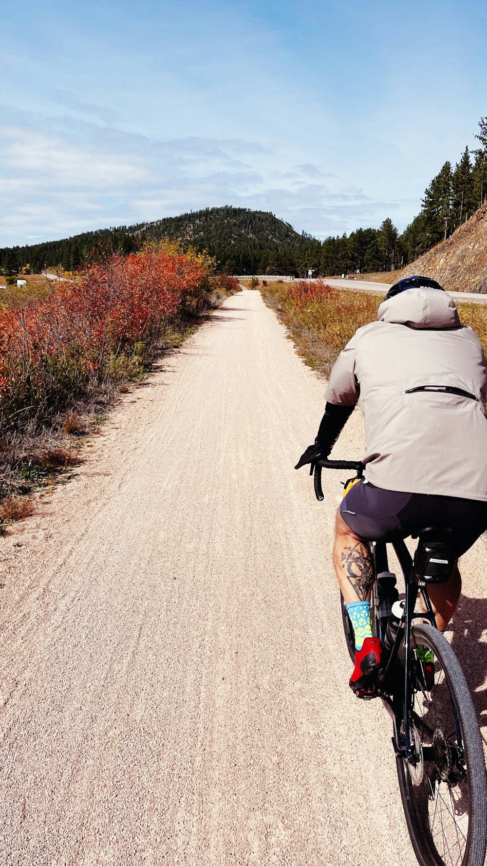 a man riding a bike down a dirt road