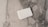 A stack of white business cards is placed on a grey and white marble surface. The surface displays a natural pattern with a mix of light and dark grey tones, creating a sleek and polished look.