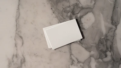 A sleek and minimalist branding mockup featuring black and white business cards arranged neatly on a marble surface.