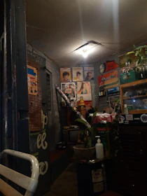 A dimly lit room with vintage music equipment and posters reflecting underground music scenes.