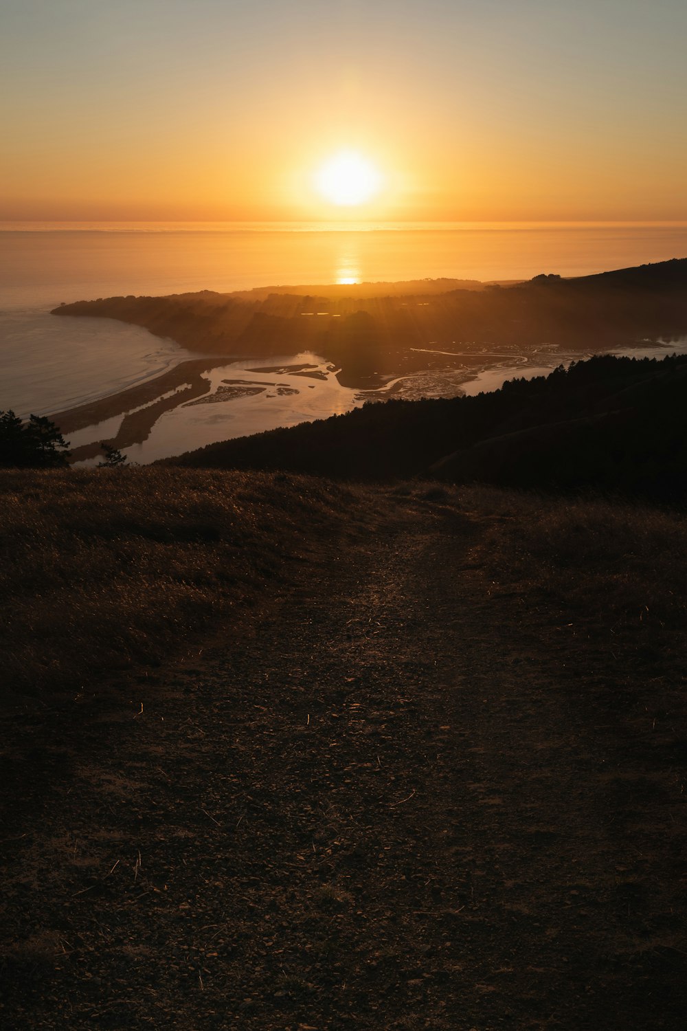 the sun is setting over a body of water