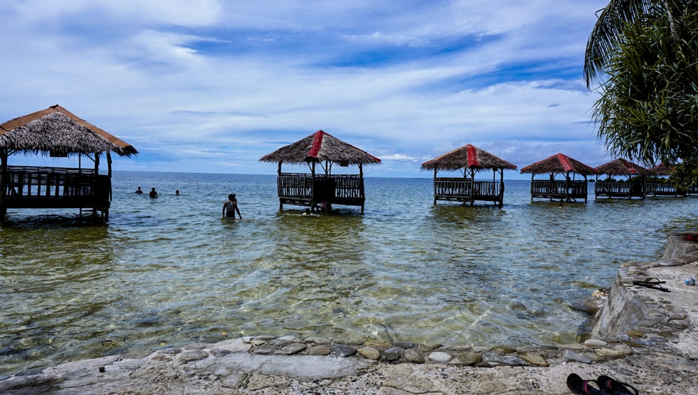 a group of huts sitting on top of a beach next to the ocean