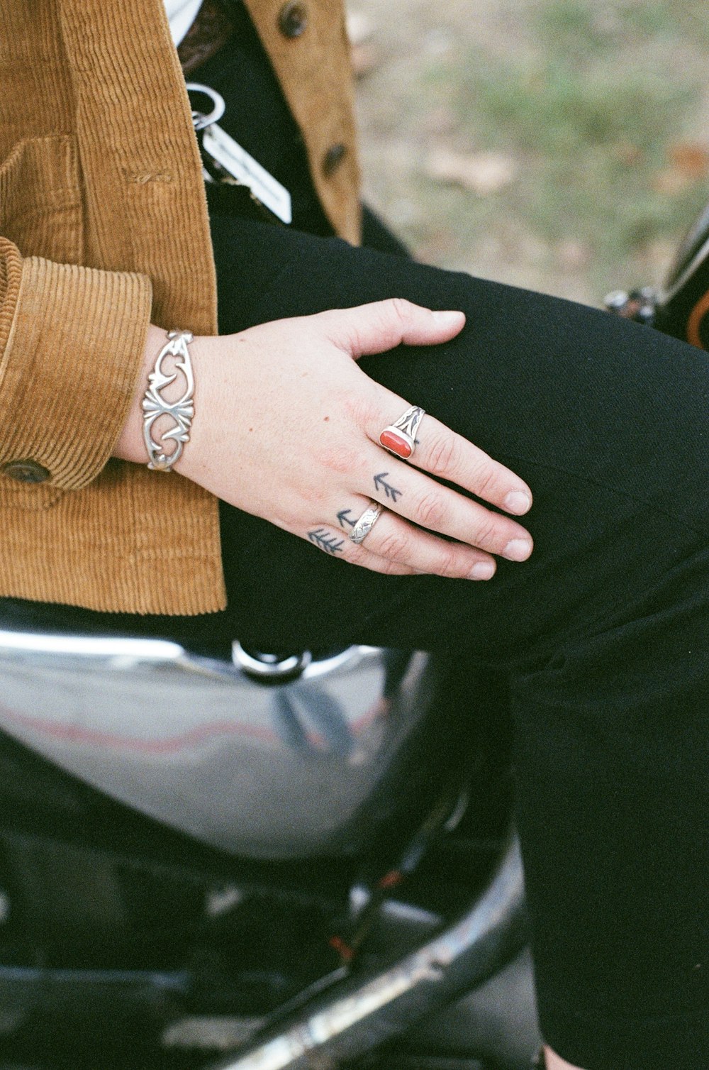 une femme assise sur une moto avec un tatouage à la main