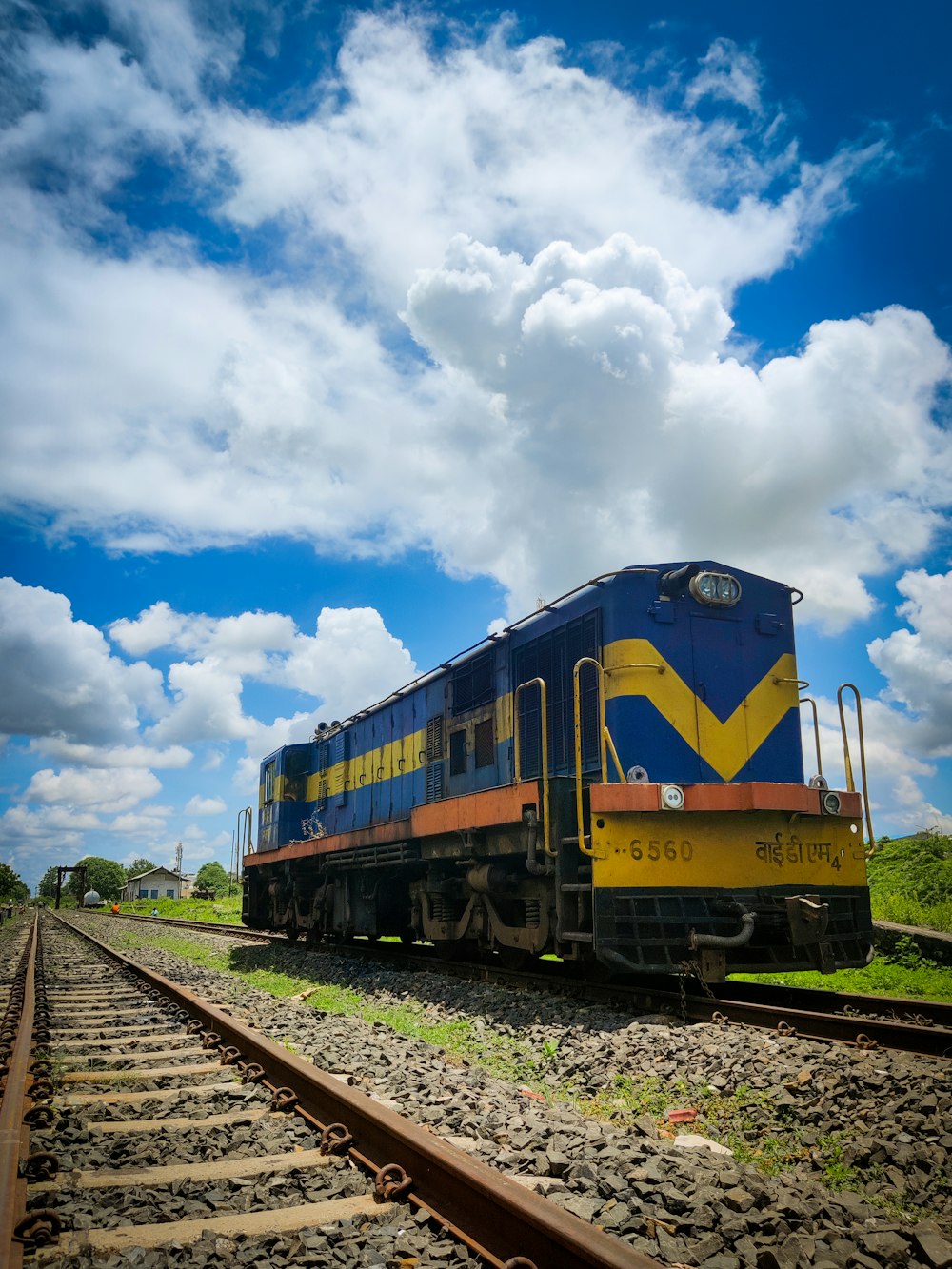 a blue and yellow train traveling down train tracks