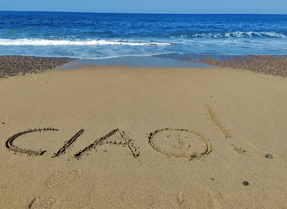 the word dad written in the sand on the beach