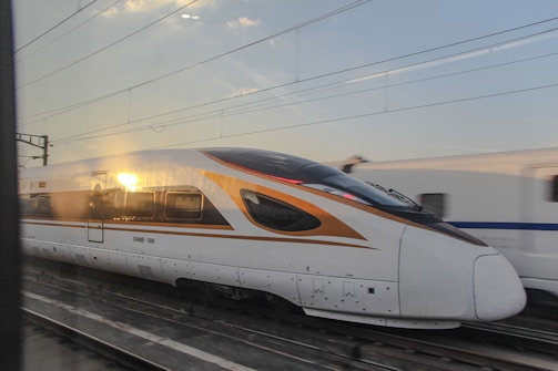 a white and orange train traveling down train tracks