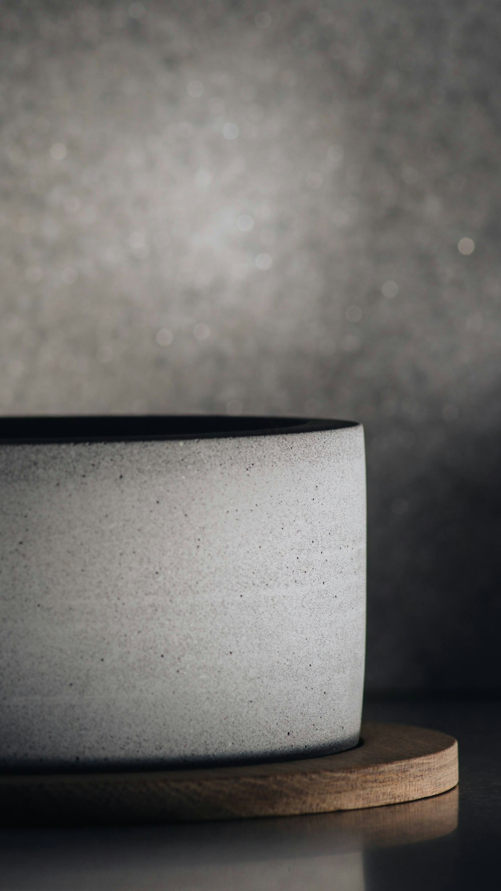 a white bowl sitting on top of a wooden stand