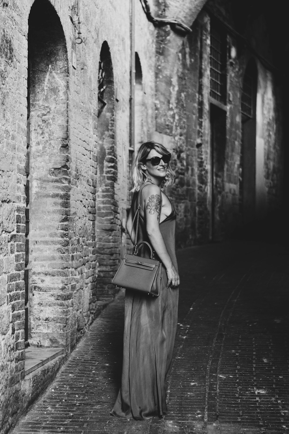 a woman in a long dress is walking down the street