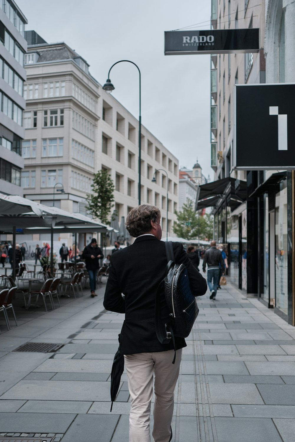 a man walking down a sidewalk in a city