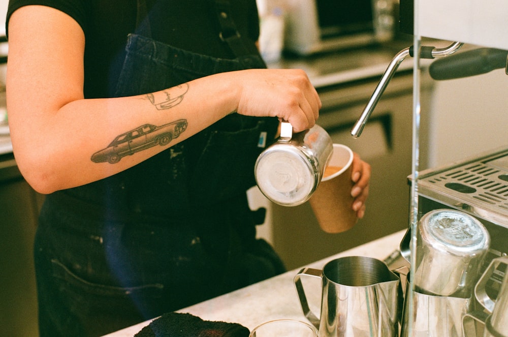 a woman pouring a cup of coffee in a kitchen